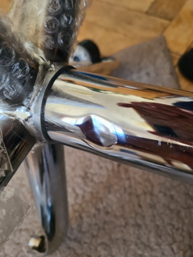 an office chair's gas lift with a dent in the outer cylinder