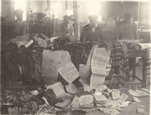 Men trying to salvage Sifrei Torah in Demiev Synagogue after pogromists in Kiev raided it. Dated 1920.