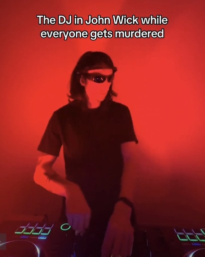 Photo of a DJ in a red room with the caption “The DJ in John Wick while everyone gets murdered”